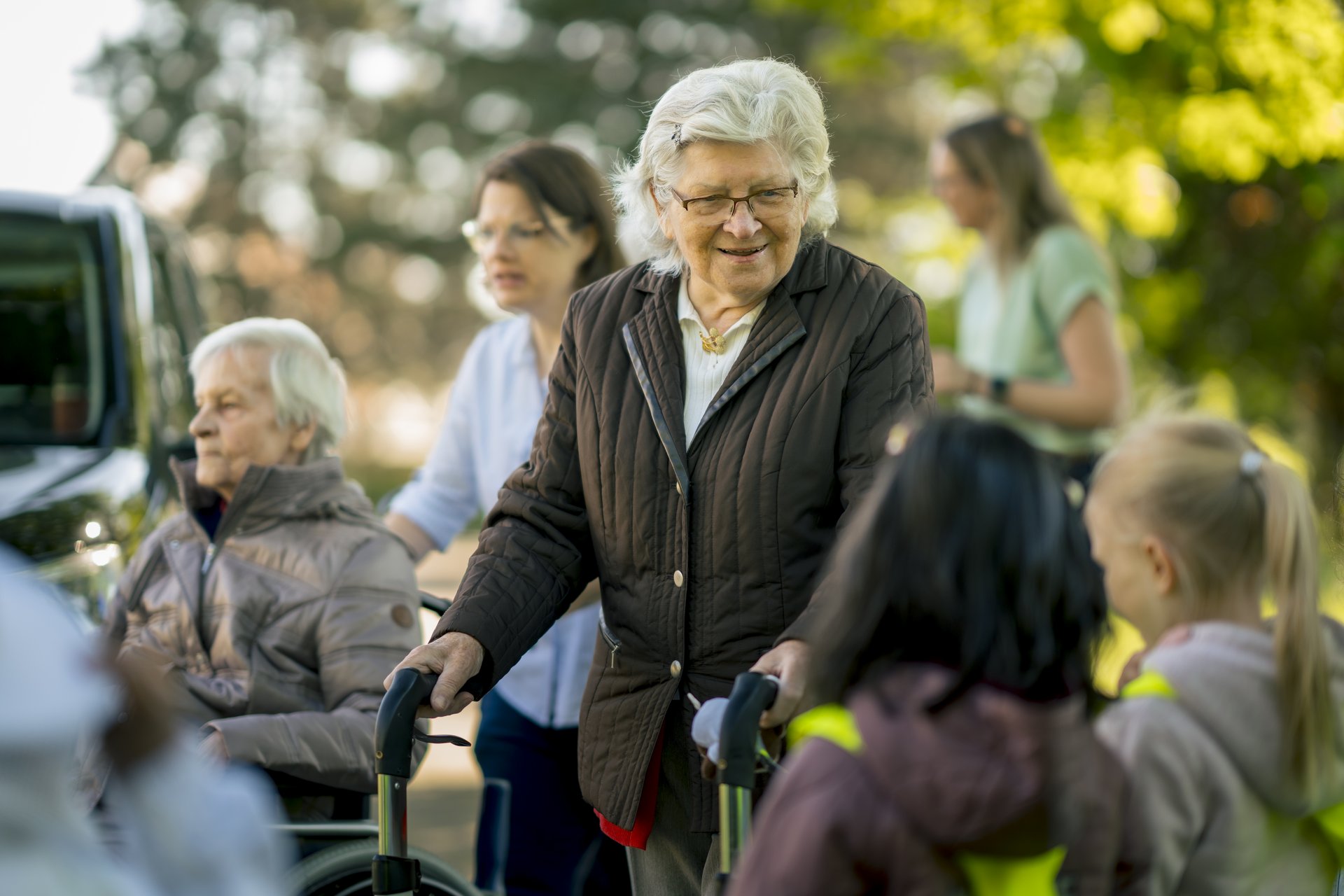 Eine Seniorin unterhält sich mit einer Kindergruppe.